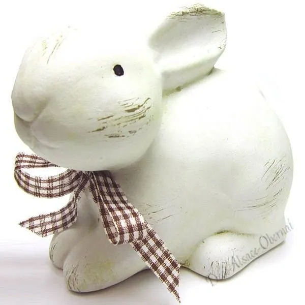 White rabbit with its decorative bow sitting in Ceramic