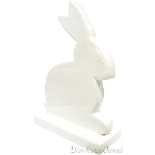 Decorative rabbit sitting on a white ceramic base
