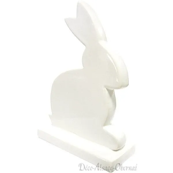 Decorative rabbit sitting on a white ceramic base