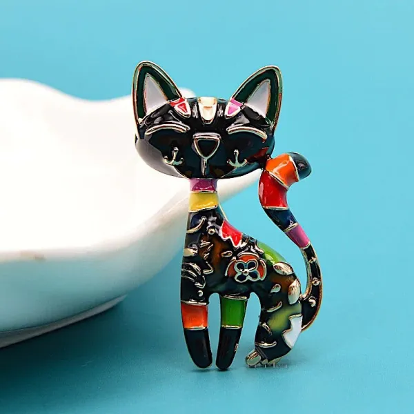 Fancy golden brooch in the shape of a black cat in color