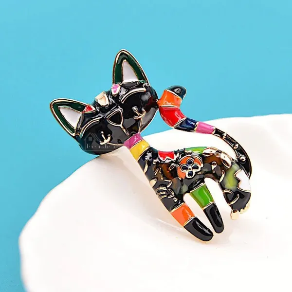 Fancy golden brooch in the shape of a black cat in color