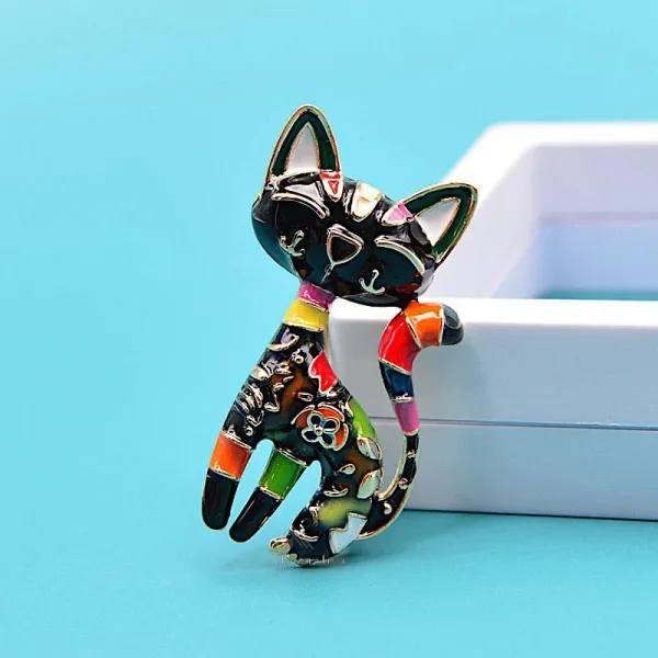 Fancy golden brooch in the shape of a black cat in color