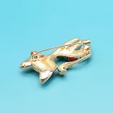 Fancy golden brooch in the shape of a black cat in color