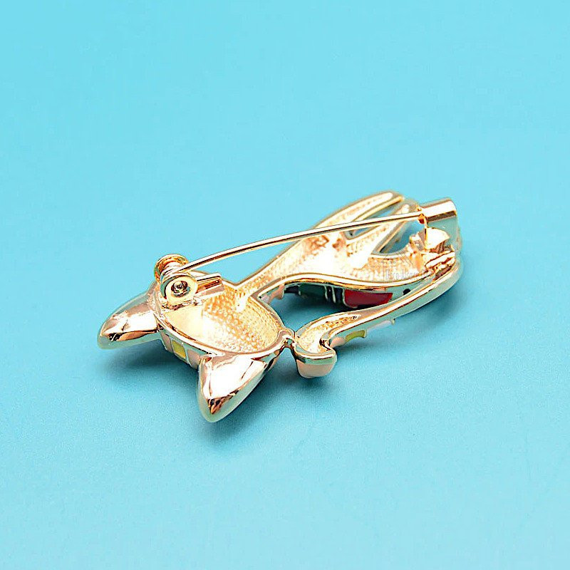 Fancy golden brooch in the shape of a black cat in color