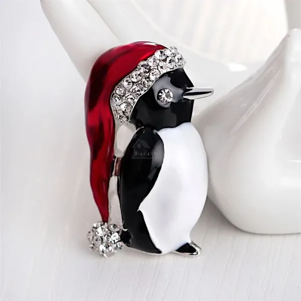 Fancy golden brooch Penguin red cap set with rhinestones