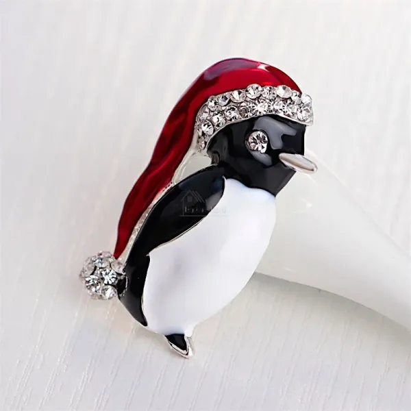 Fancy golden brooch Penguin red cap set with rhinestones