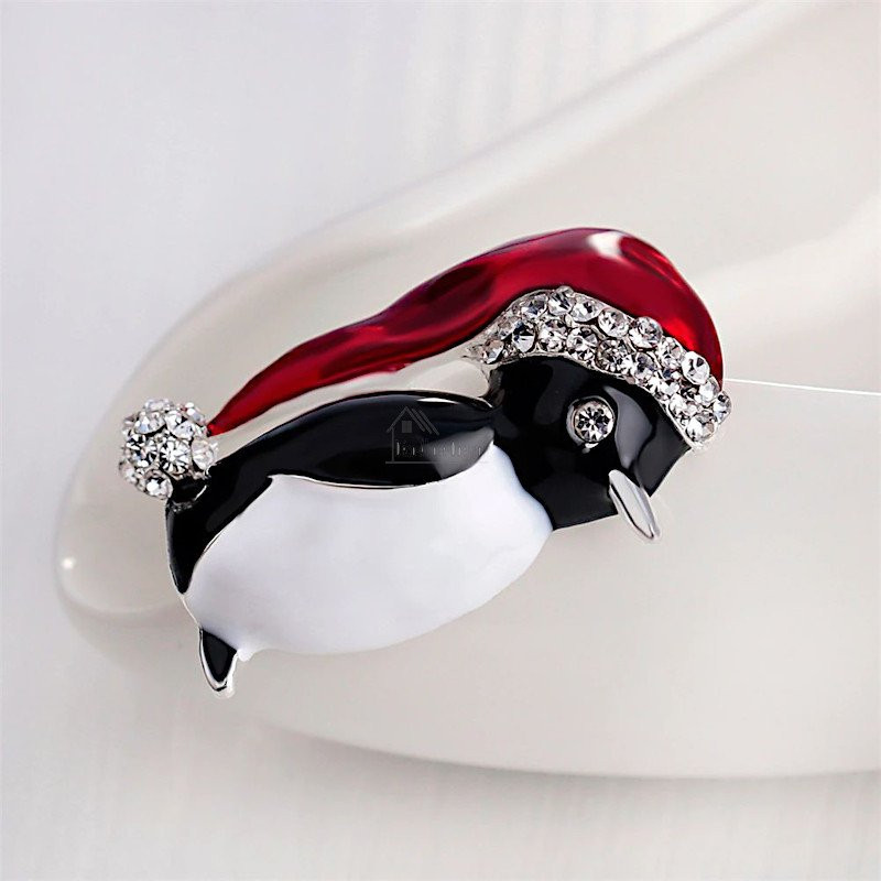 Fancy golden brooch Penguin red cap set with rhinestones